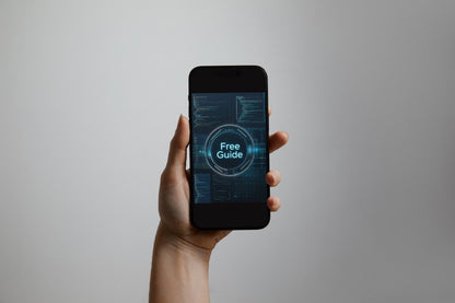 A hand holding a black smartphone against a plain light gray background. The phone screen displays a futuristic blue digital interface with the words 'Free Guide' in the center.