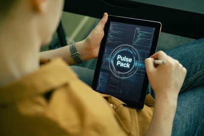 A person in a tan shirt and blue jeans holds a tablet showing a digital interface labeled 'Pulse Pack' while using a stylus.